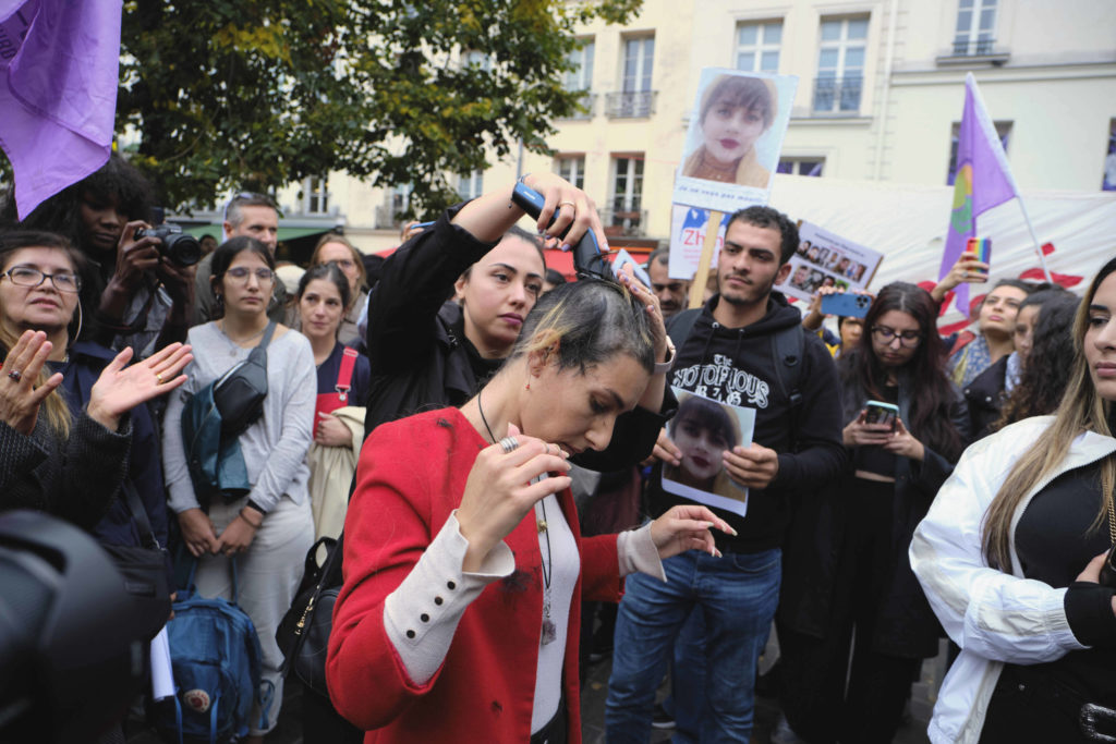 Eine Frau lässt sich in Paris aus Protest gegen den Tod von Mahsa Amini die Haare abrasieren. Quelle: IMAGO
