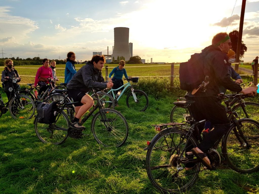 Radfahrer und Radfahrerinnen der Initiative Students for Future stehen auf einer Wiese.