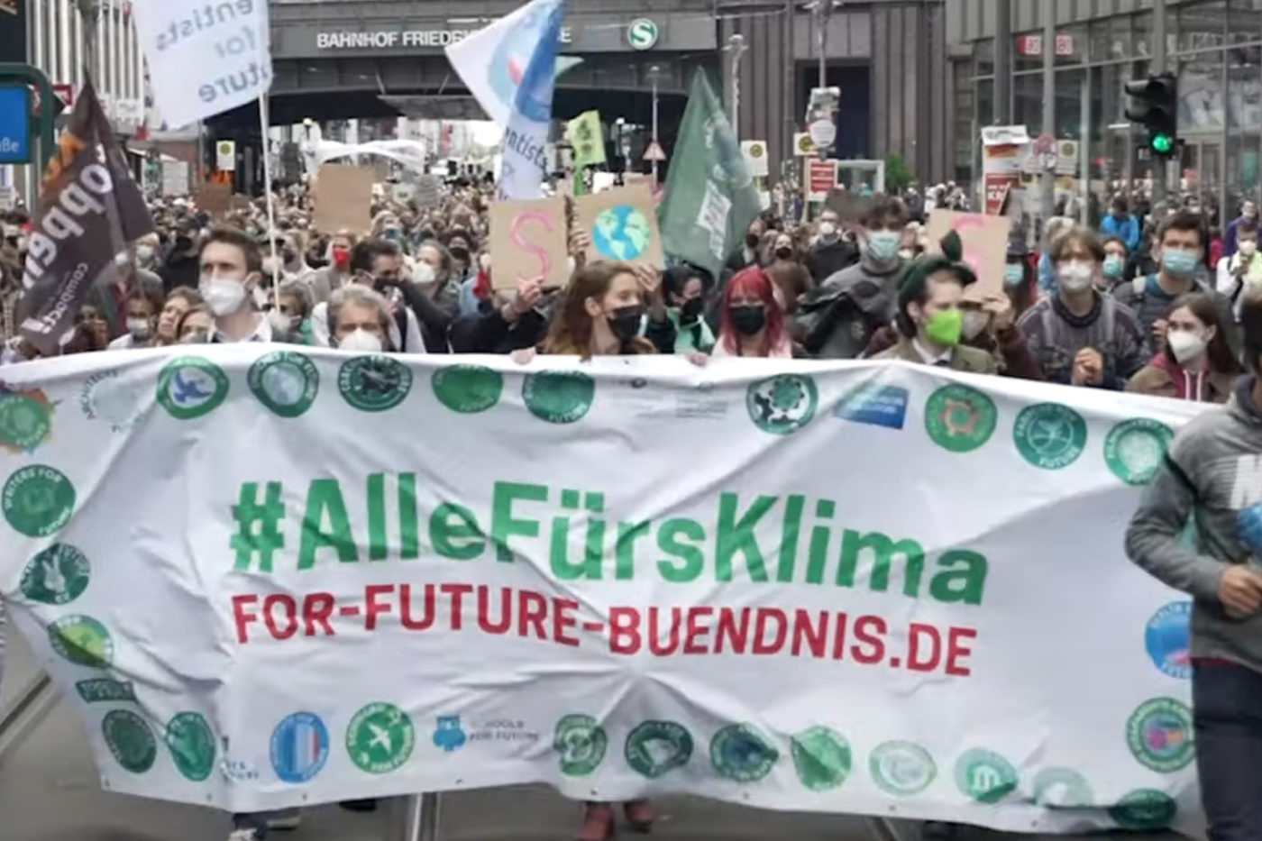 Tausende Klima-Demonstrant*innen mit Pappschildern und Fahnen laufen auf einer Straße in Berlin. Sie halten ein Banner mit der Aufschrift: #AlleFürsKlima For-Future-Buendnis.de