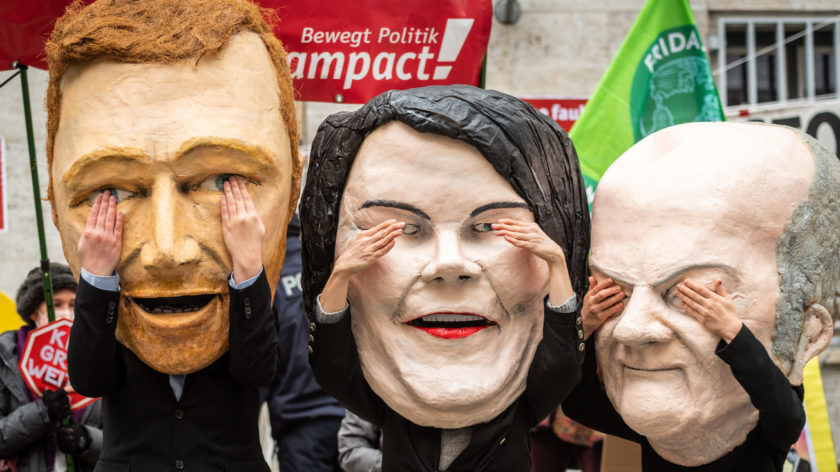 Die Spitzen der Ampel-Regierung (von links) Christian Lindner (FDP), Annalena Baerbock (Die Grünen) und Olaf Scholz (SPD) als große Pappmaché-Masken bei einer aktion in Berlin.