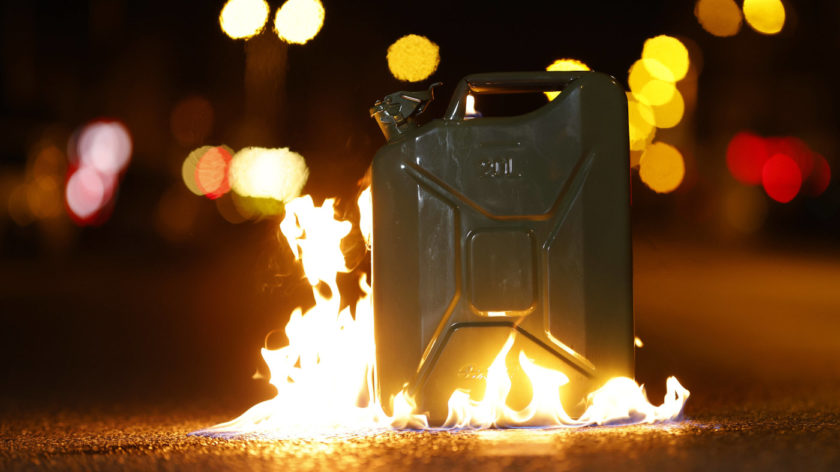 Zu sehen ist ein brennender Benzinkanister, der bei Nacht auf einer Straße steht. Symbolbild zum Thema "Peak Oil" und "Wutwinter".