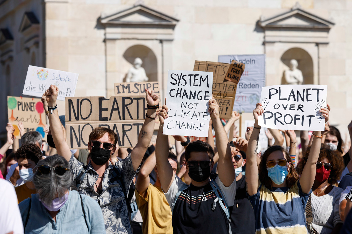 Demonstrierende beim Klimastreik 2021 in München. Sie halten Schilder mit verschiedenen Protest-Botschaften hoch, zum Beispiel "System change, not climate change".