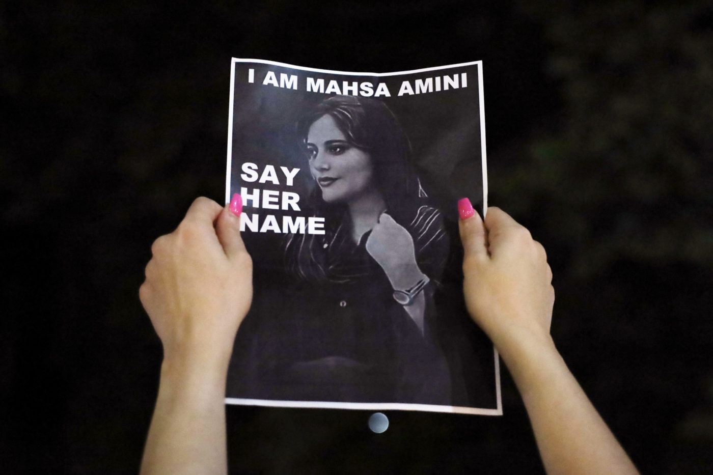 Eine Frau hält im australischen Sydney ein Foto mit dem Bild von Mahsa Amini in die Luft. Der richtige Name von "Mahsa" ist jedoch jina.
