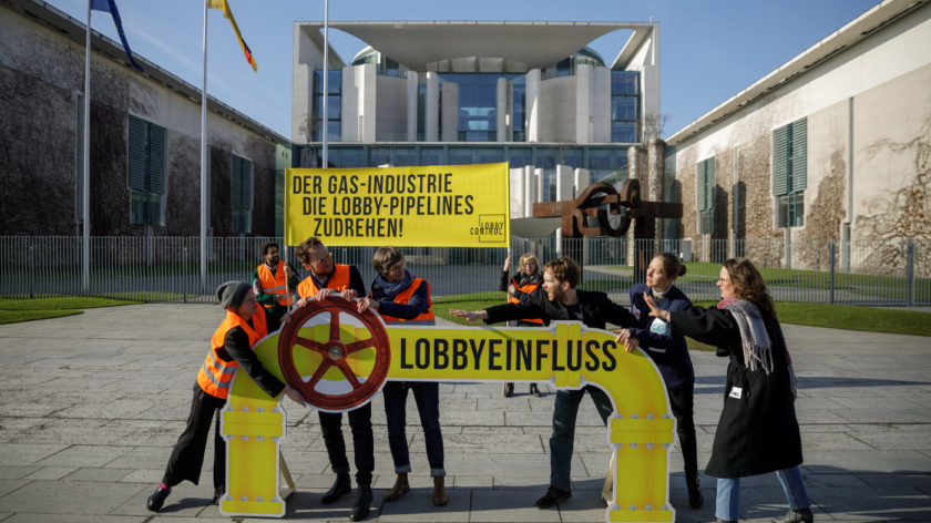Eine Gruppe Aktivisten von LobbyControl bei einer Aktion vor dem Bundeskanzleramt in Berlin. Sie protestieren dagegen, dass die Gas-Lobby viel Einfluss in die Klimapolitik nimmt.