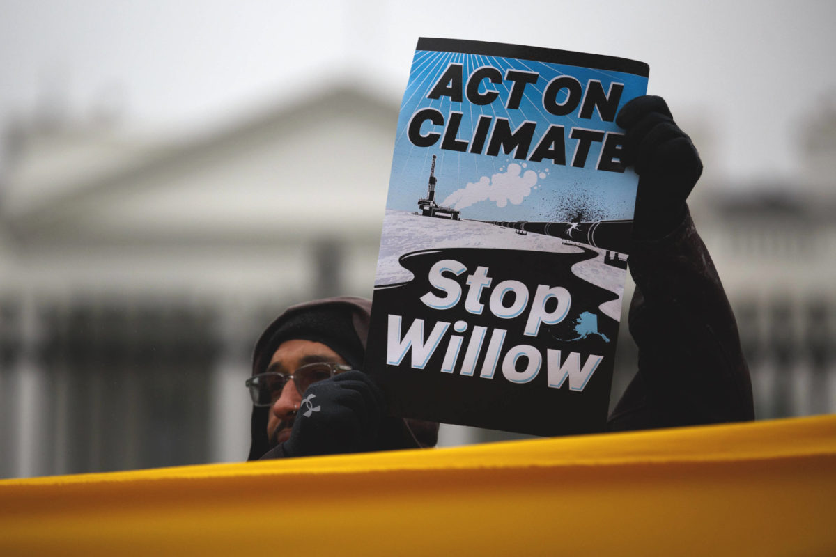 Eine Person hält vor dem Weißen Haus in Washington in den USA ein Schild hoch, auf dem steht: "Act on climate, Stop Willow" ("Handelt für das Klima, Stoppt Willow").