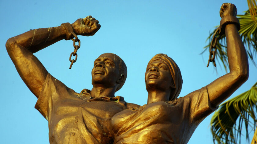 Ein Denkmal in Windhoek in Namibia, das an den deutschen Genozid der Nama und Herero erinnert. Zu sehen sind zwei Personen mit nach oben gestreckten Fäusten und zersprengten Ketten an den Händen.