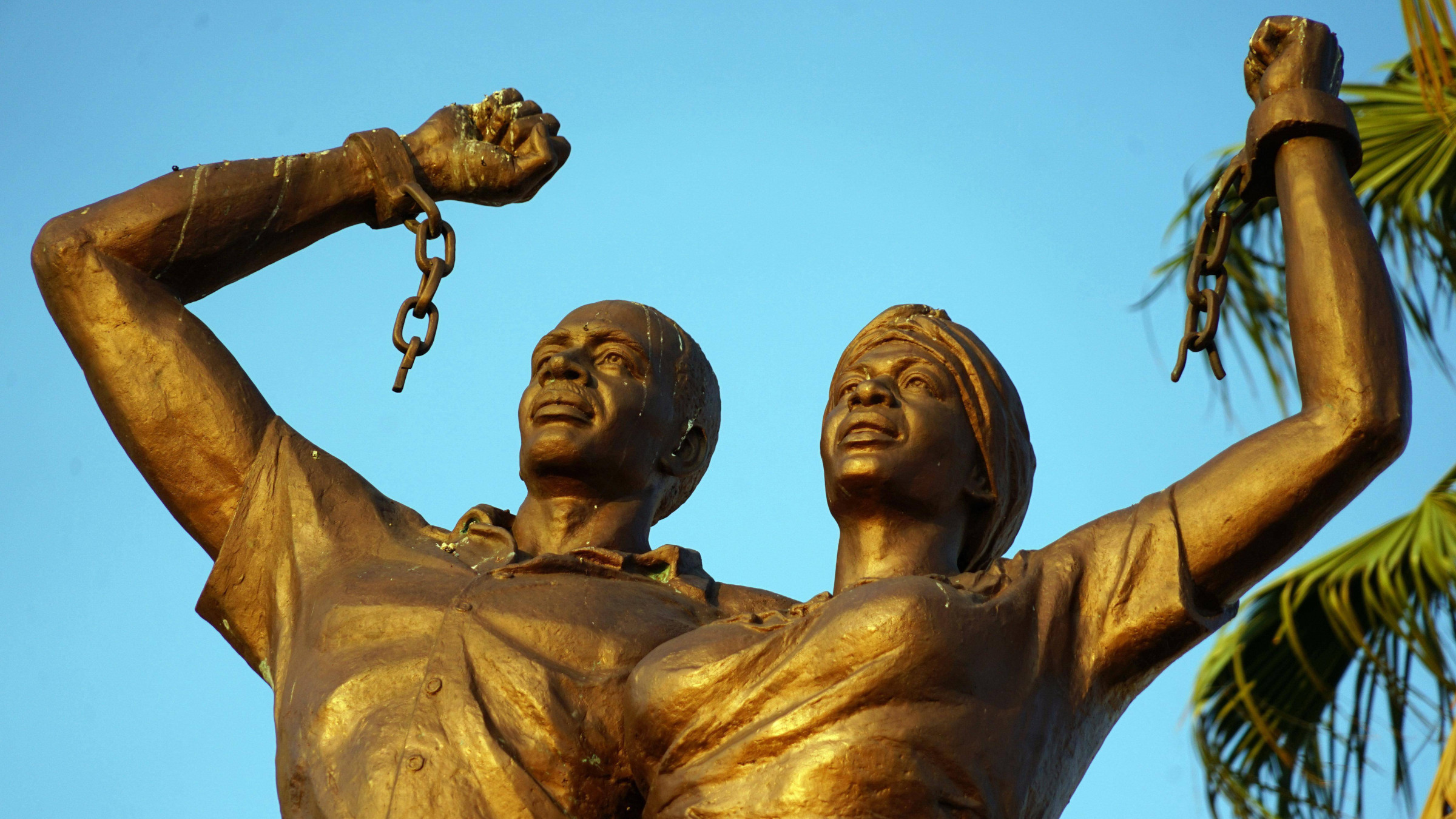 Ein Denkmal in Windhoek in Namibia, das an den deutschen Genozid der Nama und Herero erinnert. Zu sehen sind zwei Personen mit nach oben gestreckten Fäusten und zersprengten Ketten an den Händen.