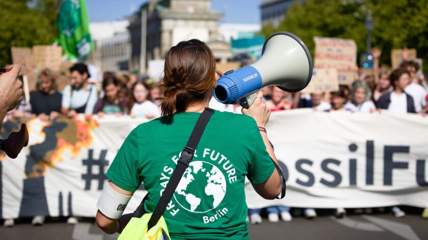 Eine Person von Fridays for Future Berlin hält bei einem Klimastreik ein Megafon in der Hand.
