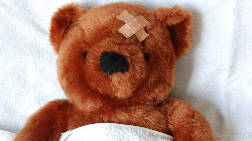 Ein kranker Teddy liegt im Bett