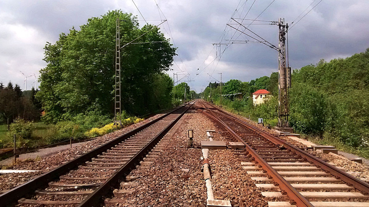 Das Foto zeigt zwei leere Bahnschienen, die vom Betrachter weg in den Horizont führen.