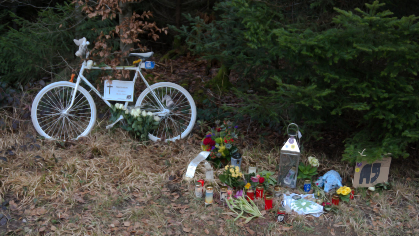 Das Foto zeigt die Gedenkstätte für "Natenom" Andreas Mandalka. Zu sehen sind ein sogenanntes Geisterrad, Trauerkerzen und Blumen an der L 574 bei Schellbronn.