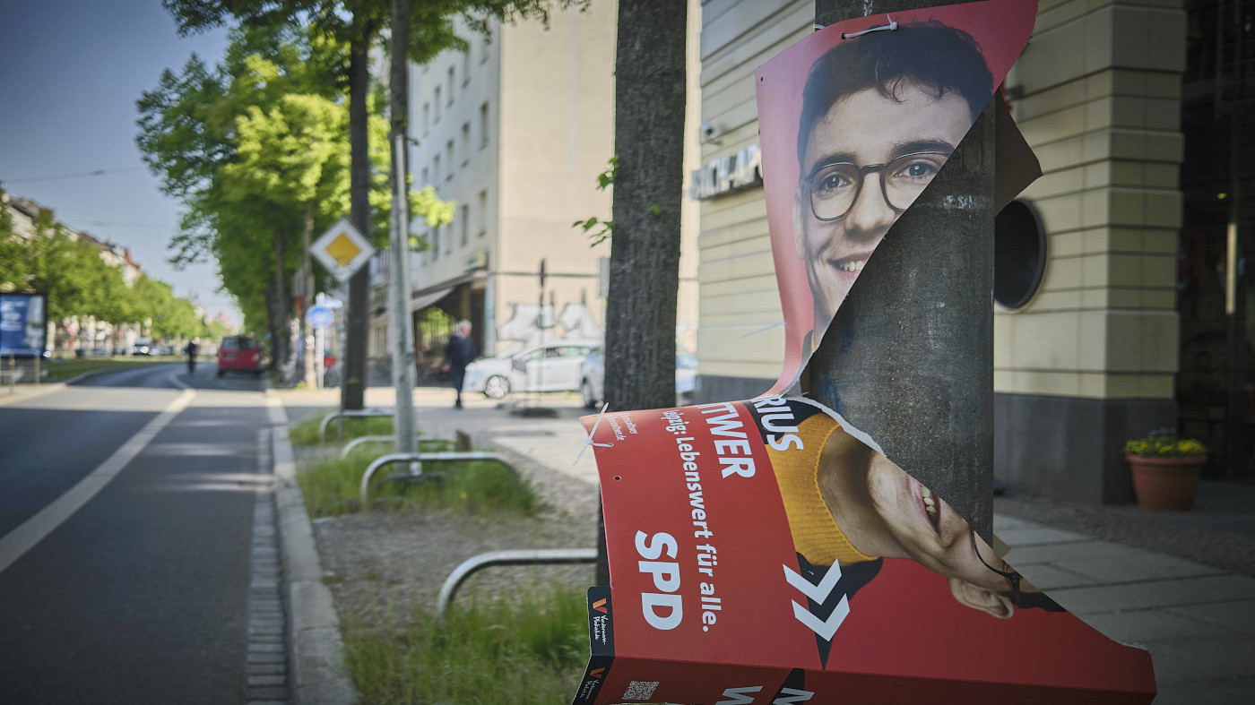 Ein frisch aufgehängtes Wahlplakat von Marius Wittwer (SPD) hängt abgerissen und durchgerissen am Mast einer Straßenlaterne in Leipzig.