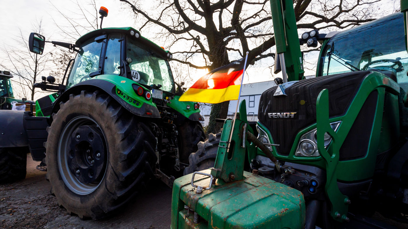 Bauernprotest in Cottbus. Deutschlandfahnen sind an einem Traktor angebracht. Bauern aus Brandenburg und der Region haben sich mit Traktoren vor dem neuen Bahnwerk in Cottbus fuer eine Protestaktion aufgestellt.