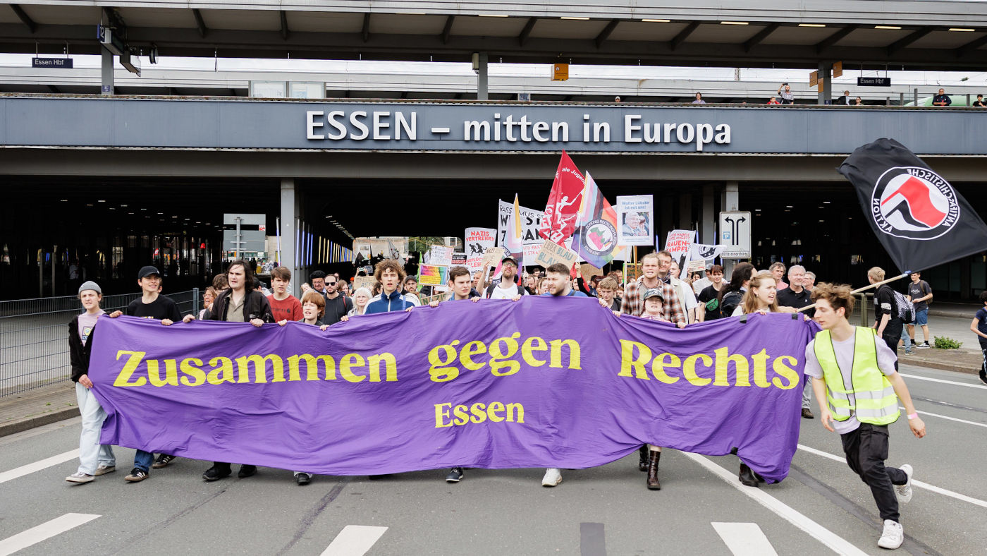 Protestierende tragen ein Banner durch die Stadt Essen in Nordrhein-Westfalen. Auf dem lila-farbenen Banner steht in gelber Schrift: "Zusammen gegen Rechts Essen".