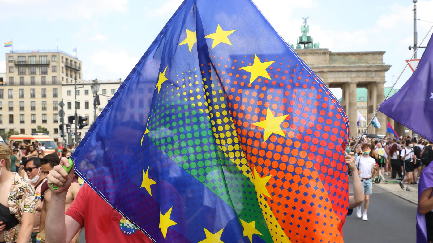 Ein Teilnehmer der Pride in Berlin 2021 schwenkt eine Mischung aus einer Europa- und einer Pride-Flagge.