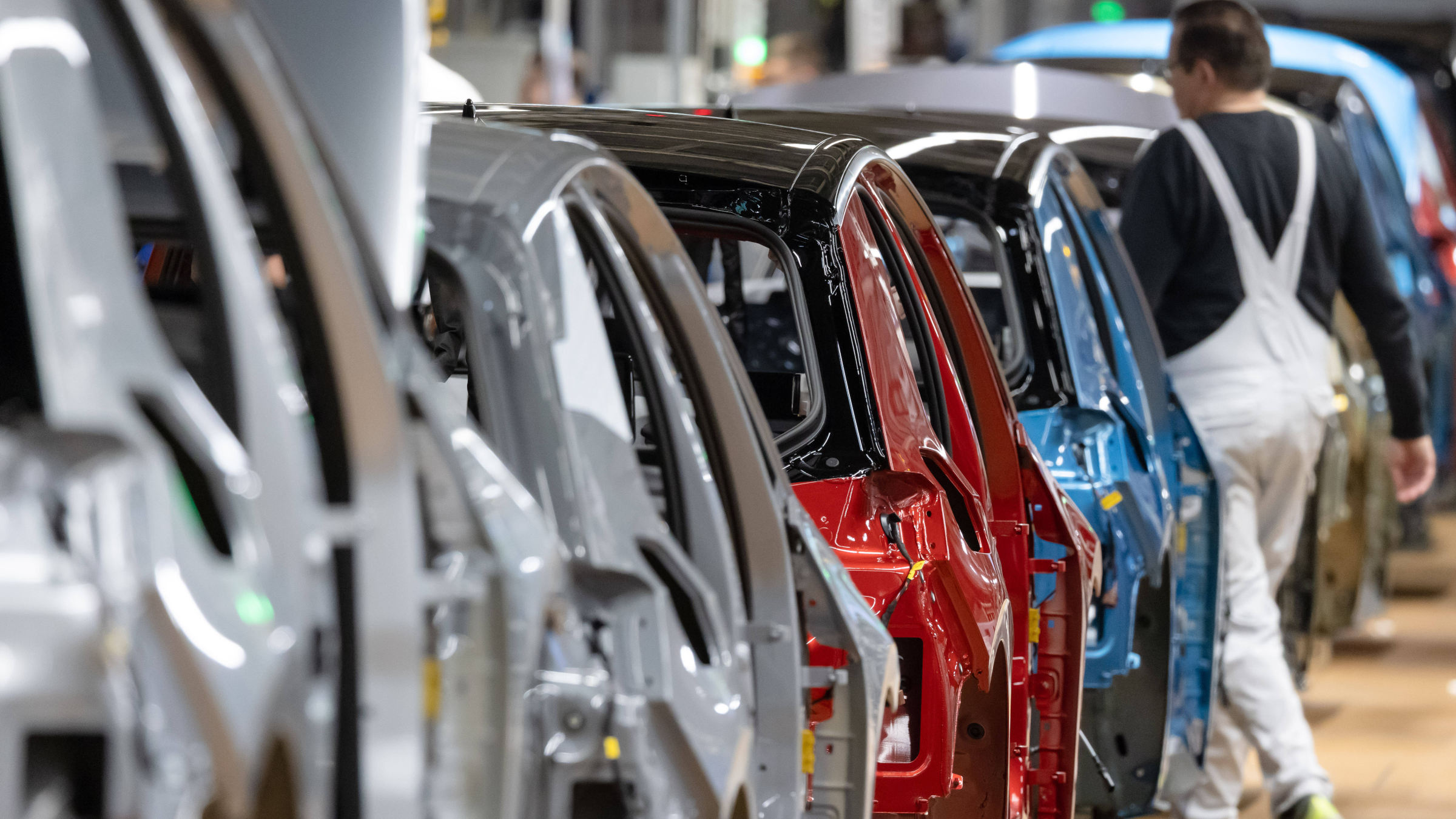 Eine Reihe von Fahrzeugrahmen für E-Autos in einem VW-Werk, stellvertretend für den Verkehrssektor.