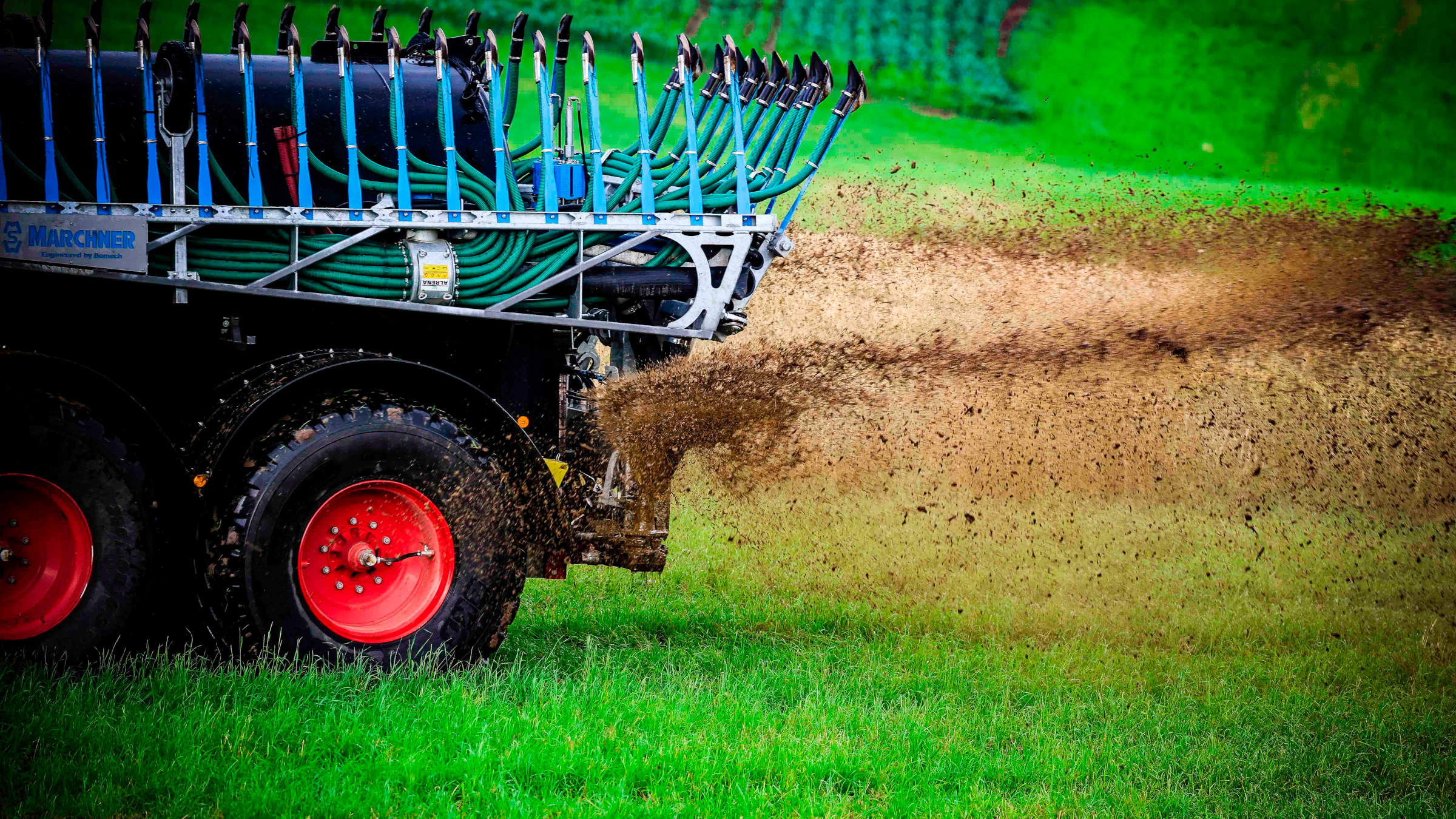 Ein Trecker fährt Gülle auf einem Feld.