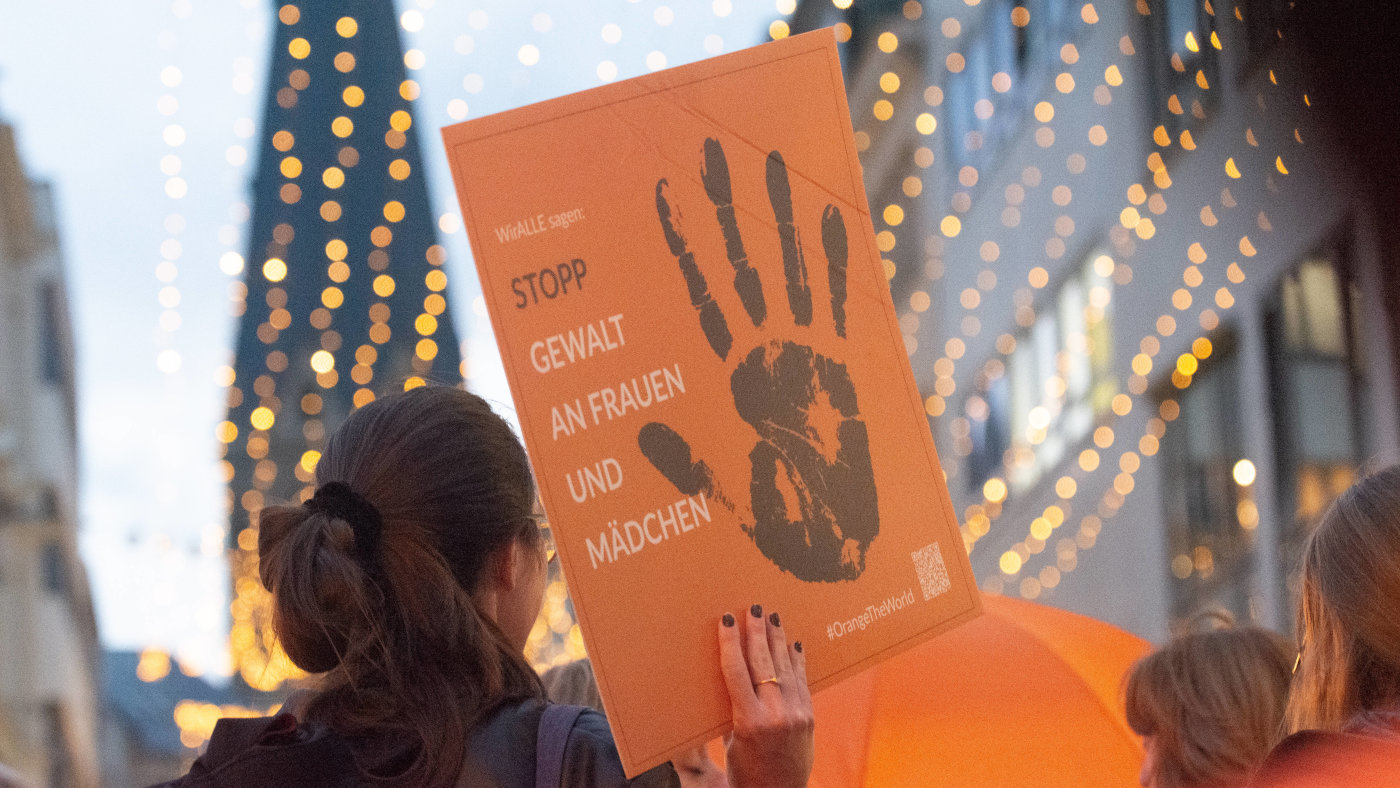 Eine Teilnehmende einer Demo am 25. November 2024 hält ein Schild hoch mit der Aufschrift: "Wir alle sagen: STOPP Gewalt an Frauen und Mädchen"