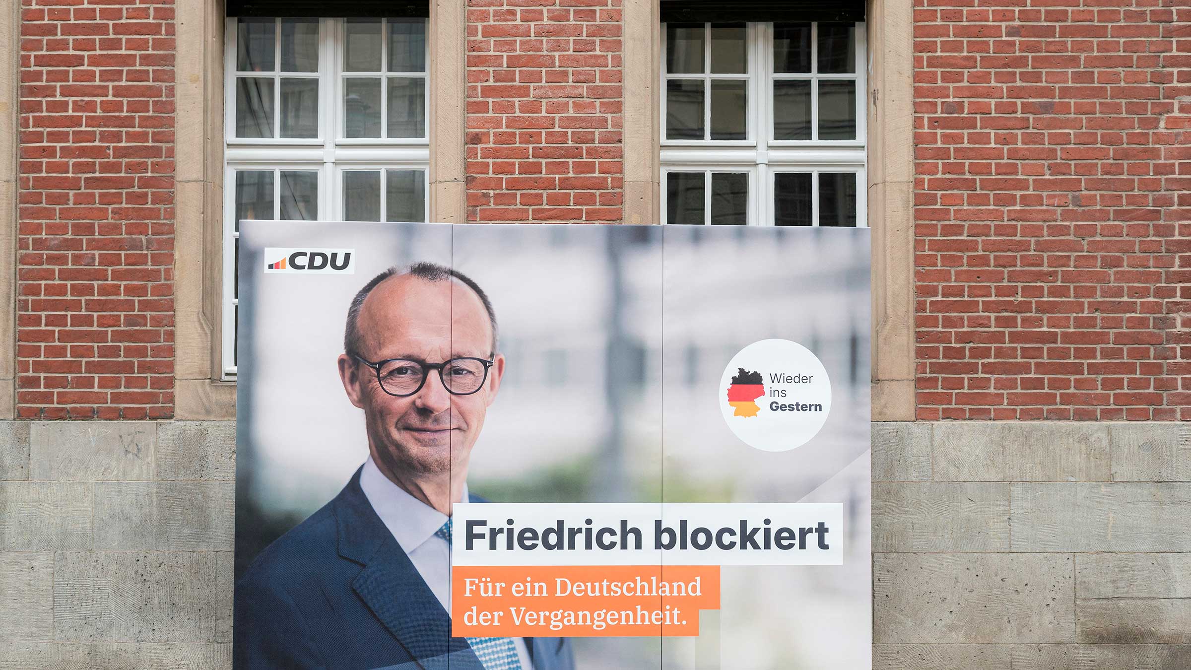 Plakat-Aktion von Campact. Auf dem Plakat zu sehen ist Friedrich Merz. Darauf steht: Friedrich blockiert. Für ein Deutschland der Vergangenheit.