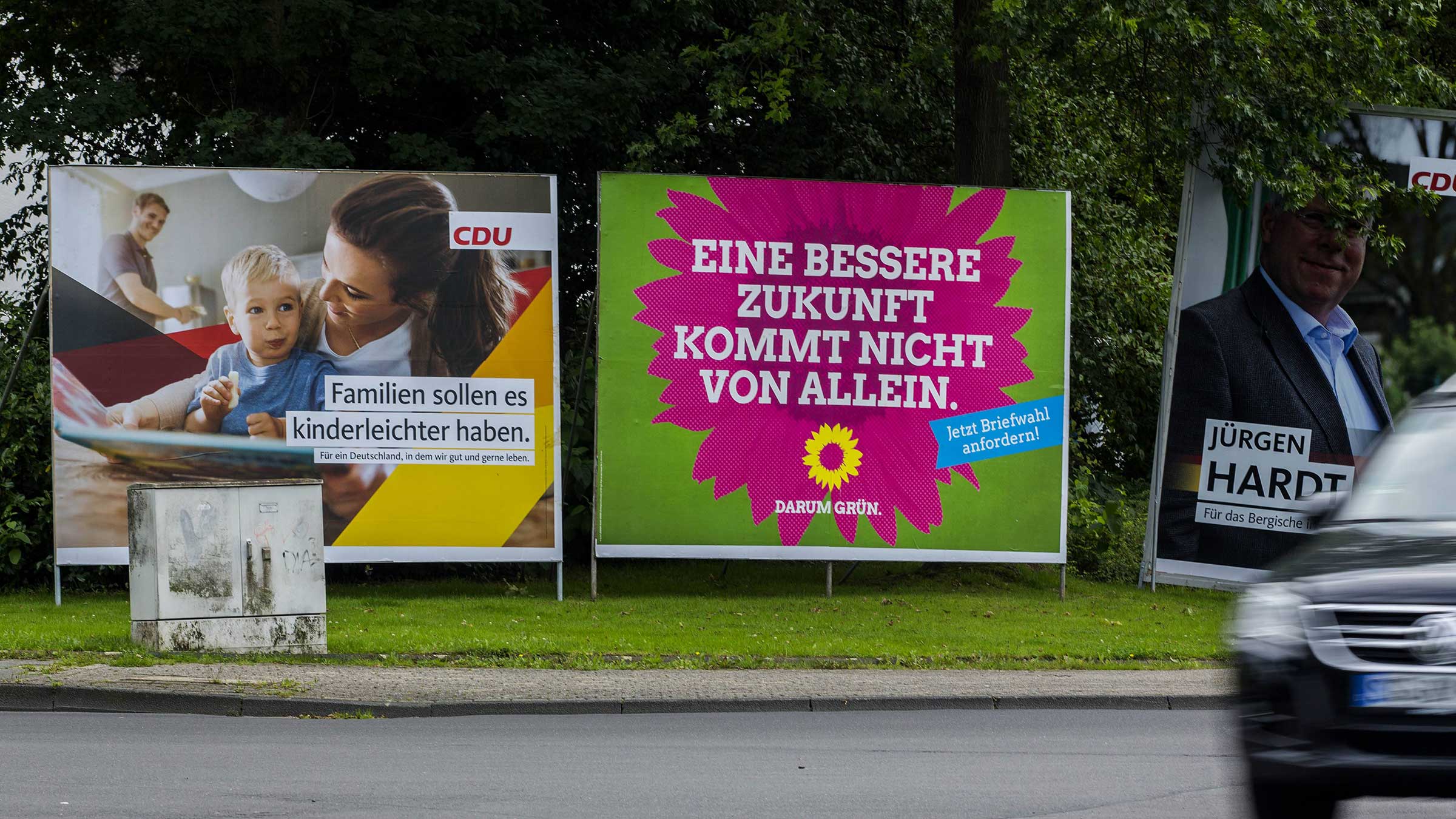 Ein Wahlplakat der Grünen - Eine bessere Zukunft kommt nicht von alleine - und der CDU - Familien sollen es kindrleicht haben - Jürgen Hardt - stehen an einer Landstraße vor der Bundestagswahl 2017 in der Nähe von Solingen