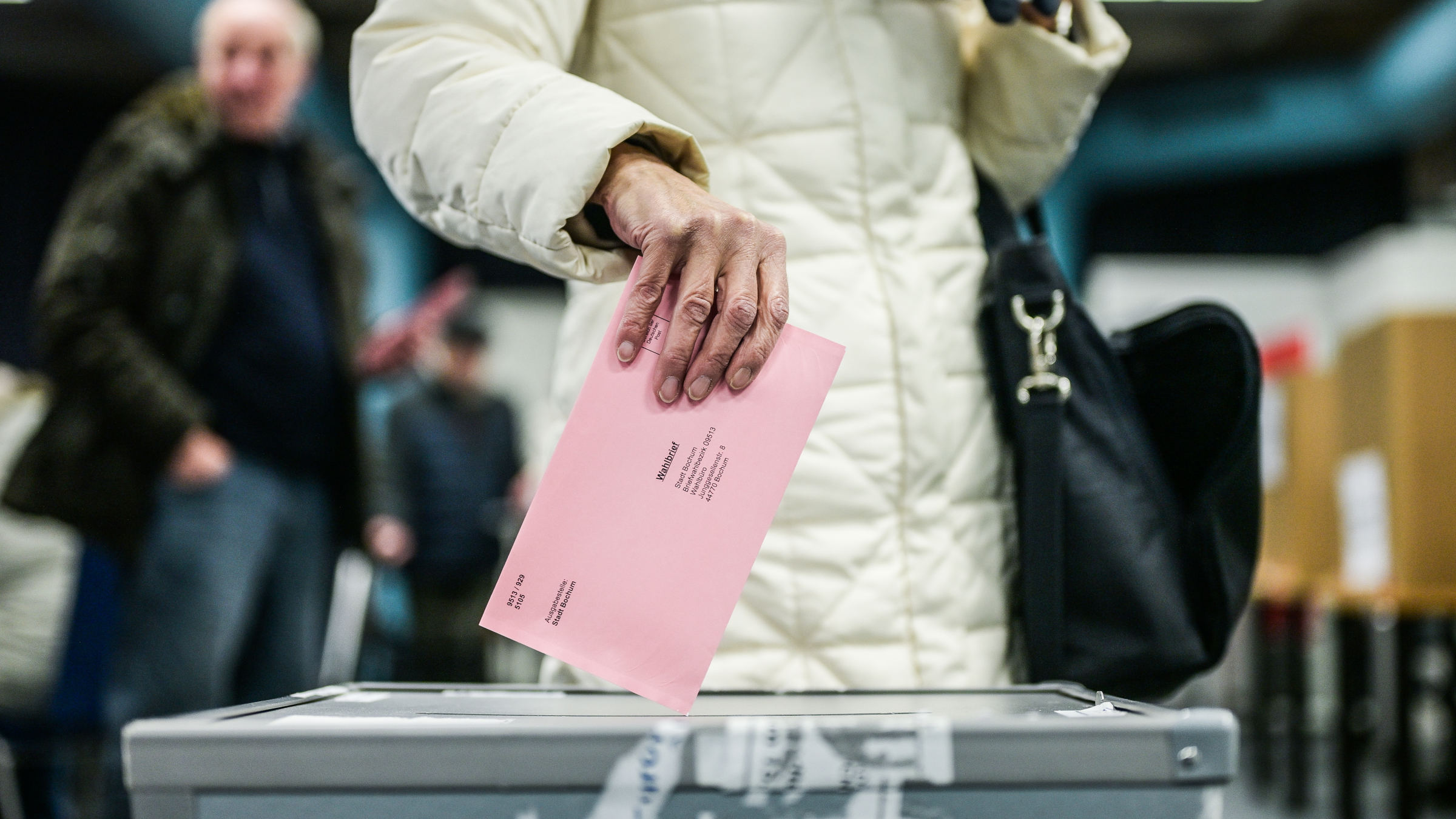 Eine Person wirft die Wahlunterlagen in die Wahlurne. Erfahre hier alles rund ums taktische Wählen bei der Bundestagswahl 2025.