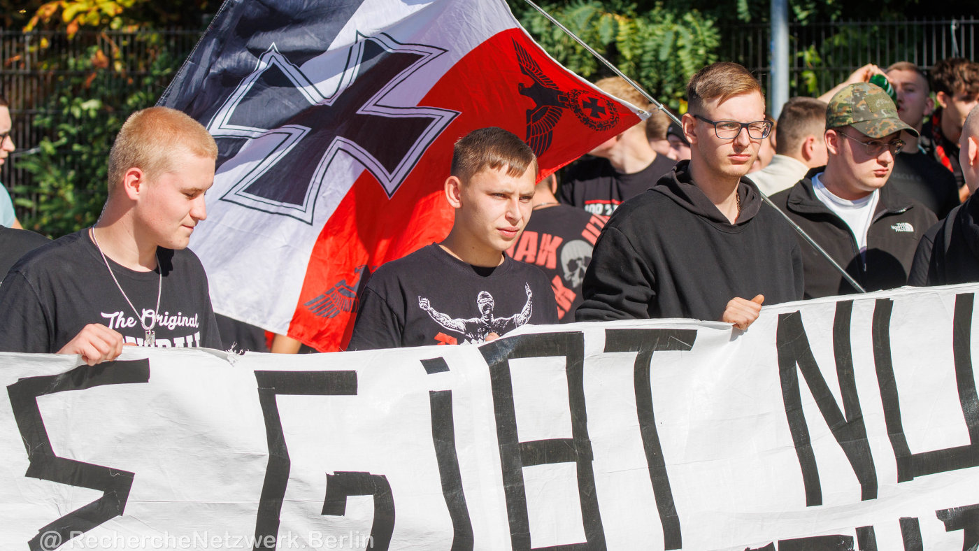 21. September 2024: Junge Männer bei einer Neonazi-Demo gegen den CSD in Oranienburg. Hinter ihnen eine schwarz-weiß-rote Reichswehrflagge. Foto: RechercheNetzwerk.Berlin